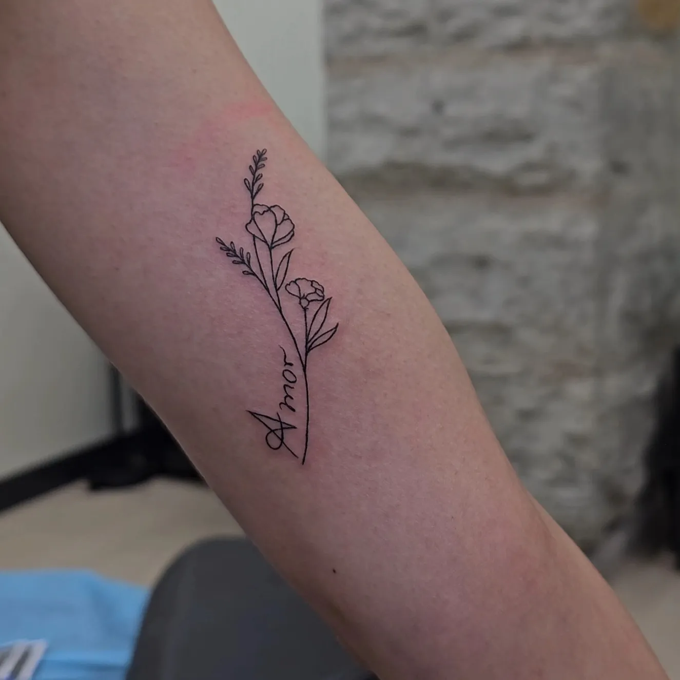 Fine line floral amor tattoo on forearm by Joan Martinez at Studio AZ Tattoo Minneapolis